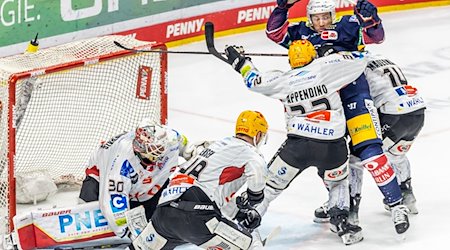 Ross Mauermann (r) und Nicolas Appendino (3.v.r) von Pinguins Bremerhaven verteidigen das Tor. / Foto: Andreas Gora/dpa