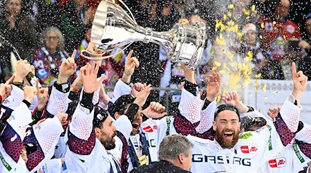 Berlins Spieler jubeln nach dem 2:0-Sieg mit dem Pokal über die zehnte deutsche Eishockey-Meisterschaft. / Foto: Carmen Jaspersen/dpa