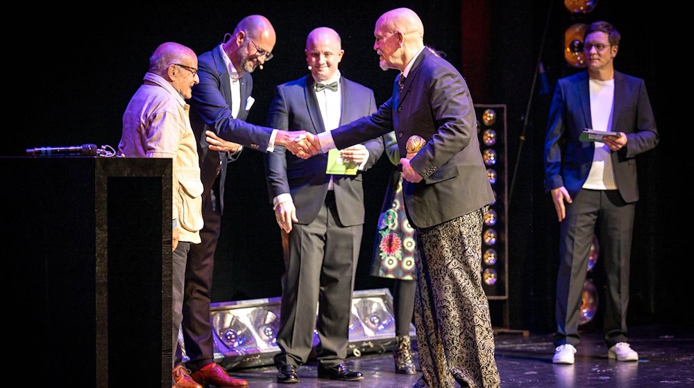 John Malkovich (2.v.r), US-Schauspieler, bekommt von Klaus Windheuser, Vorstandsmitglied der Sparkasse Bremen, den Bremer Filmpreis «Der Goldene Mops» verliehen. / Foto: Sina Schuldt/dpa