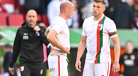 Augsburgs Sven Michel (l) und Augsburgs Ermedin Demirovic (r) reagieren nach dem Spiel unzufrieden. / Foto: Harry Langer/dpa