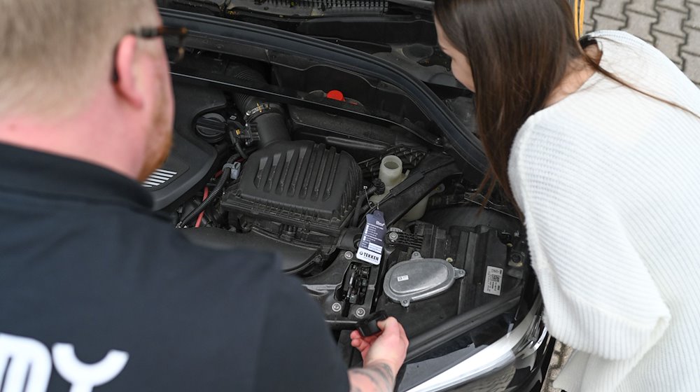 Ailt Broer, Fahrlehrer aus Aurich, erklärt seiner Fahrschülerin Lea M., die den Führerschein mit 17 erwerben möchte, die einzelnen Bauteile eines Motors. / Foto: Lars Penning/dpa