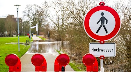 Ein Schild warnt vor dem Hochwasser, das die Aller an der Altstadt von Verden über die Ufer hat treten lassen. / Foto: Sina Schuldt/dpa