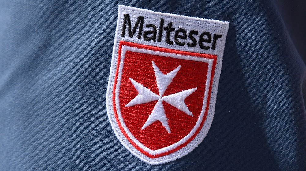Das Logo der Malteser ist an der Jacke eines Helfers zu sehen. / Foto: Robert Michael/dpa-Zentralbild/dpa