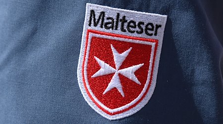 Das Logo der Malteser ist an der Jacke eines Helfers zu sehen. / Foto: Robert Michael/dpa-Zentralbild/dpa