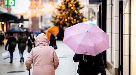 Menschen gehen bei regnerischem Wetter mit Regenschirmen durch die Innenstadt. / Foto: Hauke-Christian Dittrich/dpa/Symbolbild