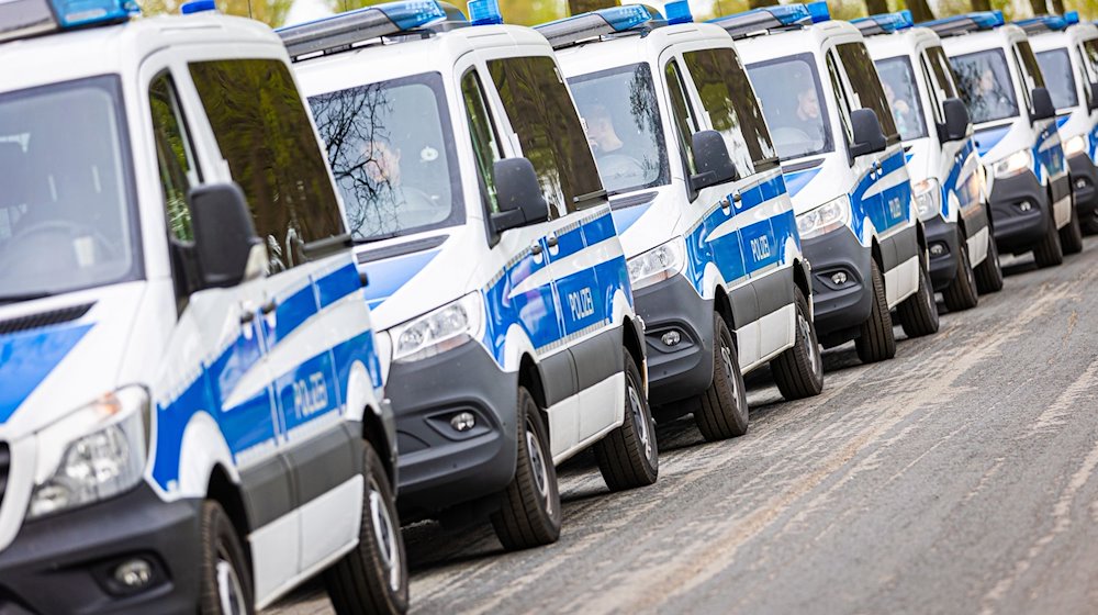 Einsatzfahrzeuge der Polizei stehen an einer Straße. / Foto: Moritz Frankenberg/dpa