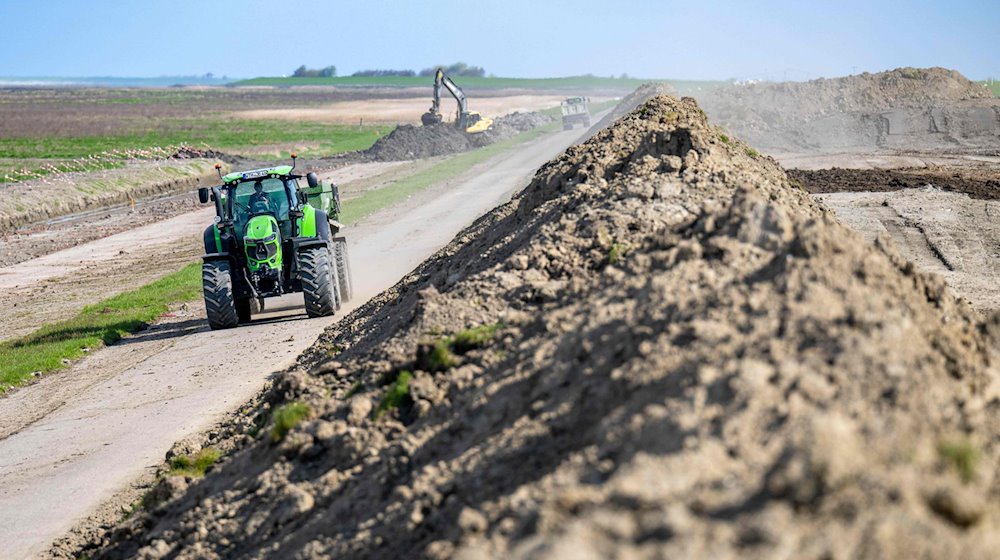 Ein Traktor fährt an einer Baustelle an einem Deich vorbei. / Foto: Sina Schuldt/dpa/Symbolbild