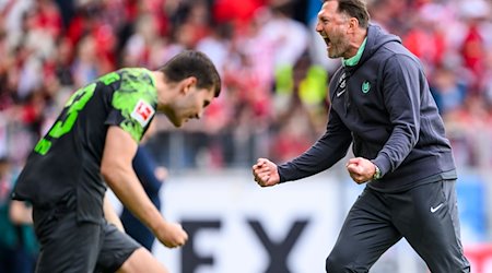 Wolfsburgs Trainer Ralph Hasenhüttl (r) jubelt nach dem Spiel mit Wolfsburgs Jonas Wind (l). / Foto: Tom Weller/dpa
