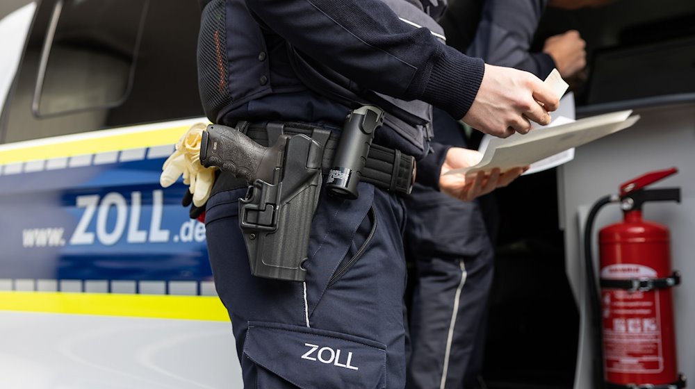 Zollbeamte überprüfen Papiere an einem Flughafen. / Foto: Hannes P Albert/dpa/Symbolbild