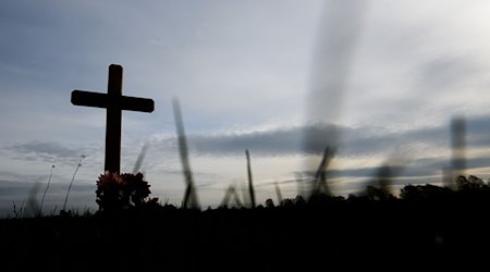 Ein Kreuz zum Gedenken an ein Opfer eines Verkehrsunfalls steht an einer Landstraße. / Foto: Julian Stratenschulte/dpa