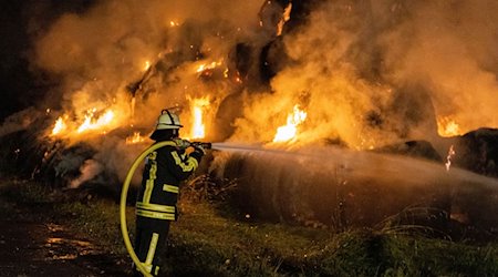Ein Feuerwehrmann löscht brennende Strohballen. / Foto: 5vision media/5vision media/dpa/Symbolbild