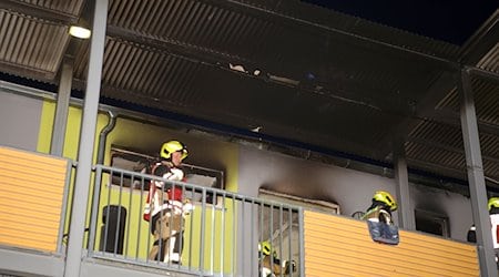 Feuerwehrleute stehen vor einer ausgebrannten Wohnung in Göttingen. / Foto: Stefan Rampfel/dpa