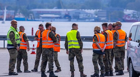 Teilnehmer der Übung National Guardian 24 der Bundeswehr warten im Seehafen Rostock. / Foto: Jens Büttner/dpa