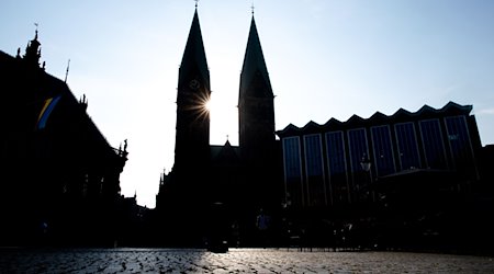 Die Sonne scheint hinter den Türmen des Sankt-Petri-Doms am Bremer Marktplatz. / Foto: Hauke-Christian Dittrich/dpa