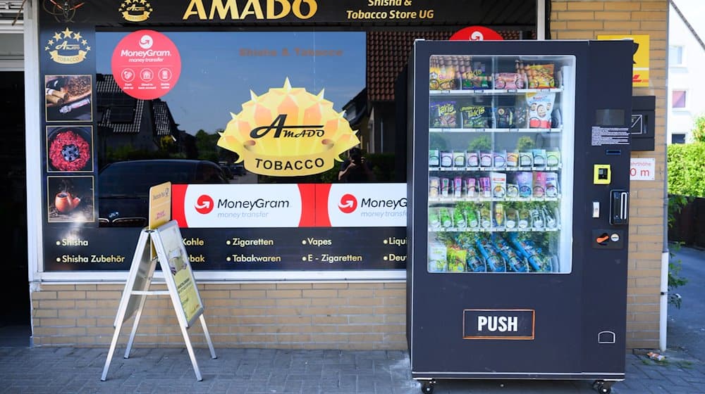 Ein Warenautomat, unter anderem mit Lachgasflaschen bestückt, steht vor einem Ladengeschäft. / Foto: Julian Stratenschulte/dpa