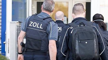 Zollbeamte betreten bei einer Razzia ein Gebäude. / Foto: Boris Roessler/dpa/Symbolbild