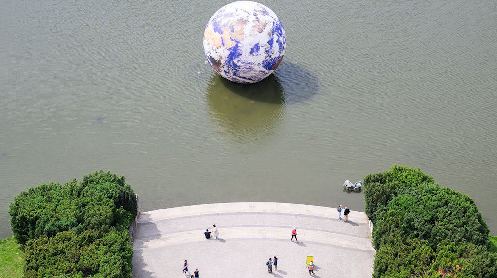 Das Kunstwerk „Floating Earth“ des Künstlers Luke Jerram schwimmt auf dem Maschteich. / Foto: Julian Stratenschulte/dpa