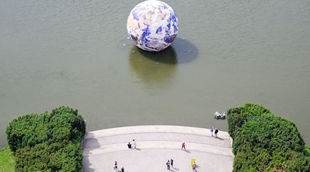 Das Kunstwerk „Floating Earth“ des Künstlers Luke Jerram schwimmt auf dem Maschteich. / Foto: Julian Stratenschulte/dpa