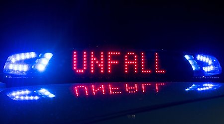 Das Blaulicht auf einem Fahrzeug der Polizei leuchtet in der Dunkelheit, während auf dem Display der Hinweis «Unfall» zu lesen ist. / Foto: Monika Skolimowska/dpa-Zentralbild/dpa