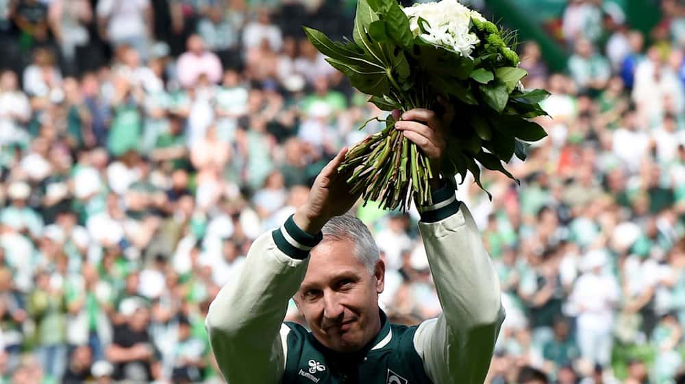 Frank Baumann, Geschäftsführer Fußball beim SV Werder Bremen, wird mit einem Blumenstrauß verabschiedet. / Foto: Carmen Jaspersen/dpa