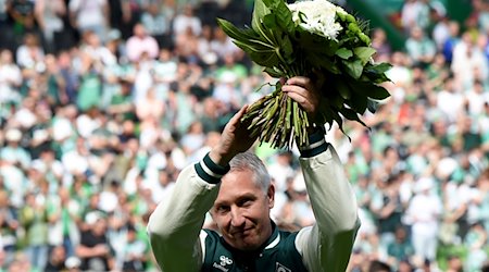 Frank Baumann, Geschäftsführer Fußball beim SV Werder Bremen, wird mit einem Blumenstrauß verabschiedet. / Foto: Carmen Jaspersen/dpa