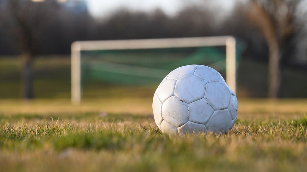 Ein Fußball liegt auf einem Fußballplatz. / Foto: Tobias Hase/dpa