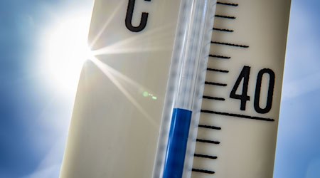 Ein Außenthermometer zeigt vor dem blauen Himmel und der Sonne eine Temperatur von nahezu 40 Grad Celsius an. / Foto: Frank Rumpenhorst/dpa