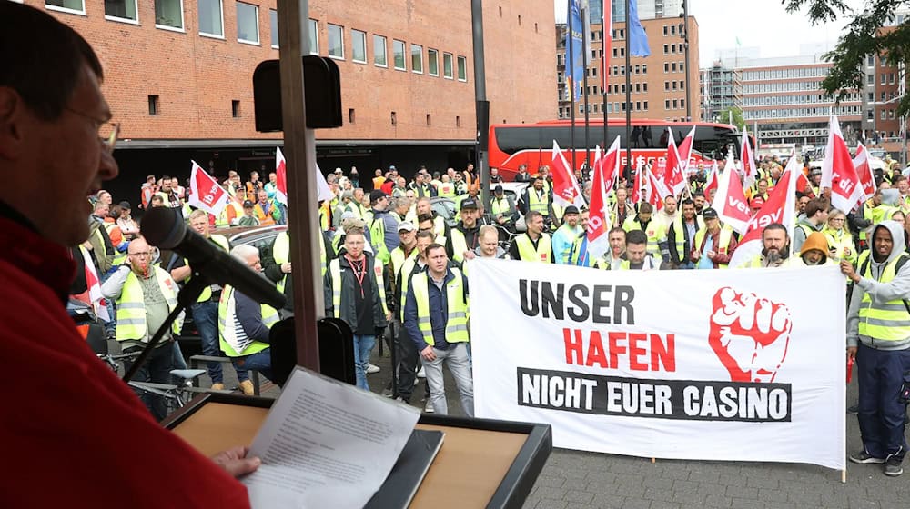 Vor Beginn einer Demonstration stehen streikende Hafenarbeiter bei einer Kundgebung zusammen. / Foto: Bodo Marks/dpa