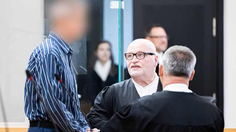 Der Angeklagte (l-r) steht vor Prozessbeginn in einem Gerichtssaal im Landgericht Hannover. / Foto: Michael Matthey/dpa