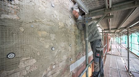 Ein Arbeiter ist mit der Sanierung eines Gebäudes beschäftigt. / Foto: Andreas Arnold/dpa/Symbolbild
