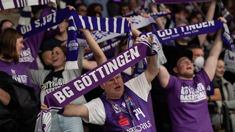 Göttinger Fans stehen mit ihren Schals auf der Tribüne und feiern. / Foto: Swen Pförtner/dpa