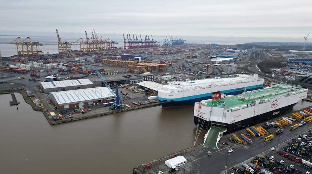 Auf dem Bild ist das Autoterminal in Bremerhaven zu sehen, im Hintergrund stehen Kräne des Containerterminals. / Foto: Lars Penning/dpa/Archivbild