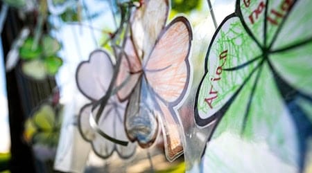 Gebastelte vierblättrige Kleeblätter mit der Aufschrift «Arian» hängen an einem Zaun im Wohnort von Arians Familie. / Foto: Sina Schuldt/dpa