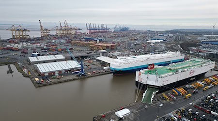 Auf dem Bild ist das Autoterminal in Bremerhaven zu sehen, im Hintergrund stehen Kräne des Containerterminals. / Foto: Lars Penning/dpa