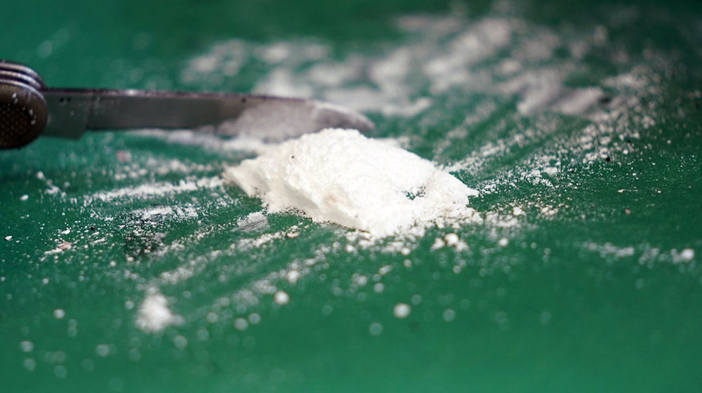 Ein Pressesprecher des Zolls präsentiert einen kleinen Teil eines sichergestellten Kokainfundes. / Foto: Marcus Brandt/dpa