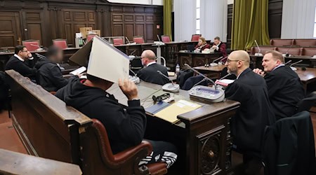 Die Angeklagten, ihre Anwälte und Vertreterin und Vertreter der Bundesanwaltschaft (hinten) sitzen im Saal. / Foto: Christian Charisius/dpa-Pool/dpa