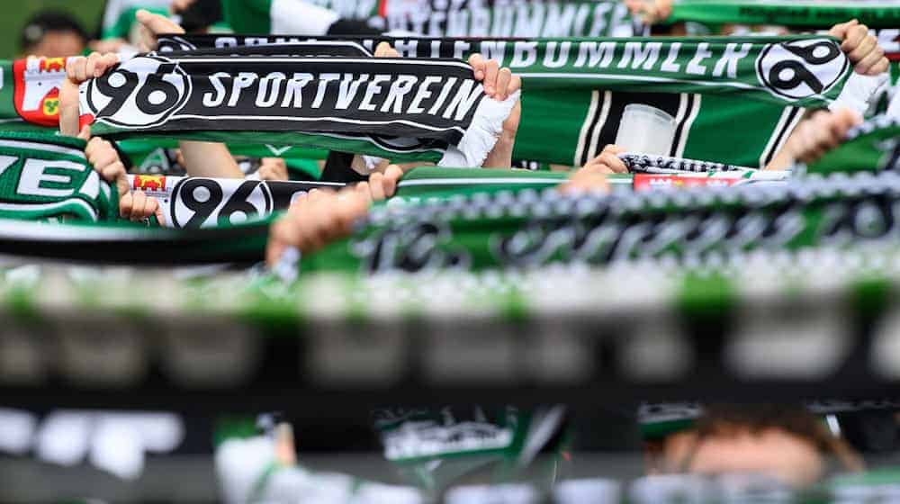 Hannovers Fans stehen mit ihren Schals auf der Tribüne. / Foto: Swen Pförtner/dpa