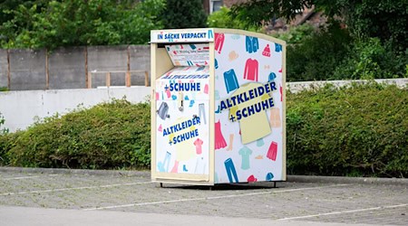 Ein Altkleidercontainer steht auf einem Supermarkt-Parkplatz. / Foto: Julian Stratenschulte/dpa