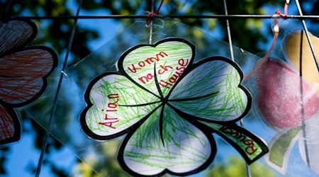 Ein gebasteltes vierblättriges Kleeblatt mit der Aufschrift „Arian komm nach Hause“ hängt an einem Zaun. Der Junge aus Bremervörde wird seit dem 22. April vermisst. / Foto: Daniel Bockwoldt/dpa