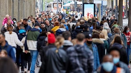 Passanten gehen über eine Einkaufsstraße. / Foto: Georg Wendt/dpa/Archivbild