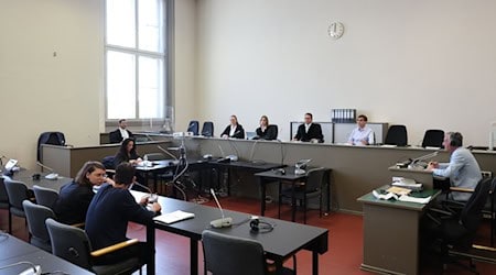 Der Angeklagte (vorn) und seine Rechtsanwältin Anna Carlotta Bloch sitzen kurz vor Beginn der Verhandlung in einem Gerichtssaal des Strafjustizgebäudes in Hamburg. / Foto: Ulrich Perrey/dpa