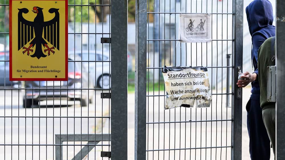 Ein Mann betritt neben einem Schild vom Bundesamt für Migration und Flüchtlinge die Landesaufnahmebehörde Niedersachsen am Standort Braunschweig. / Foto: Julian Stratenschulte/dpa