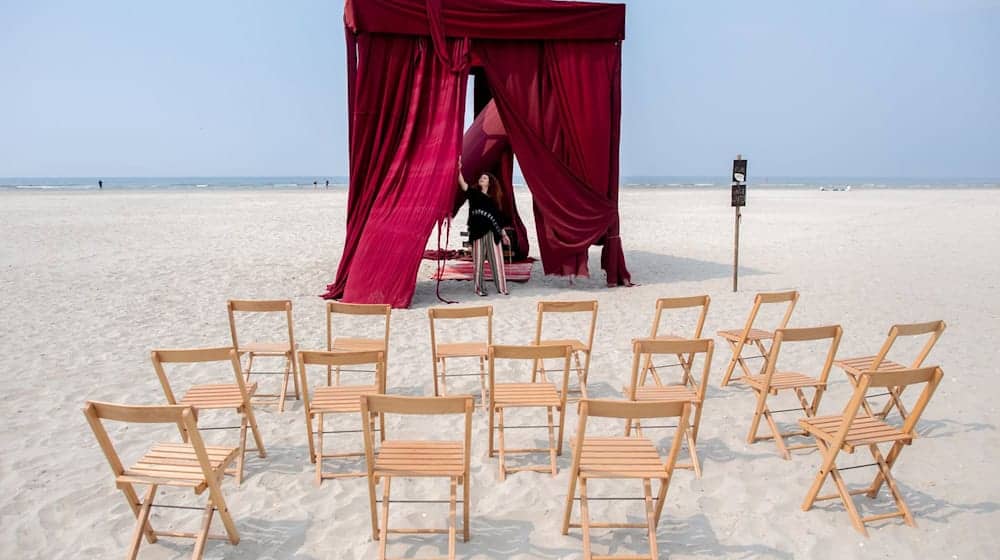 Iulia Grigoriu, rumänische Theaterregisseurin mit Wohnsitz in Berlin, bereitet am Strand der Insel einen Theatervorhang für die Aufführung vor. / Foto: Hauke-Christian Dittrich/dpa