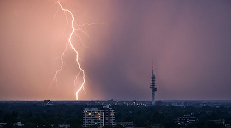 Ein Blitz entlädt sich während eines Gewitters hinter dem Fernmeldeturm Telemax. / Foto: Julian Stratenschulte/dpa