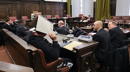 Die Angeklagten, ihre Anwälte und Vertreter der Bundesanwaltschaft (hinten) sitzen vor Prozessbeginn im Gerichtssaal. / Foto: Christian Charisius/dpa-Pool/dpa