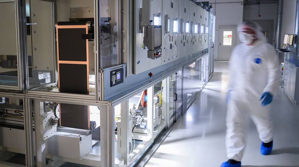 Mitarbeiter stehen in einer Pilotanlage zur Batteriezellenproduktion im VW-Werk Salzgitter an einer Beschichtungsanlage für Elektroden. / Foto: Julian Stratenschulte/dpa