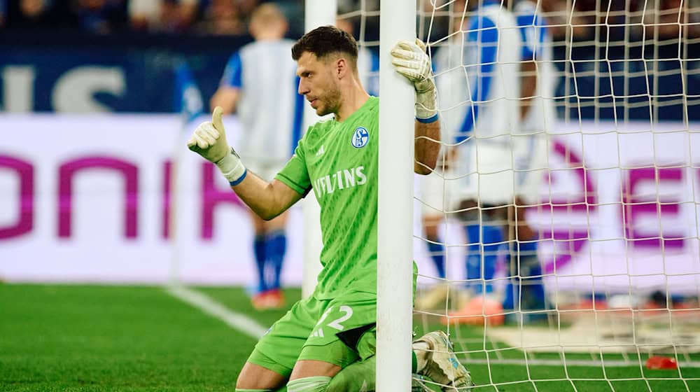 Schalkes Torwart Marius Müller dirigiert kniend seine Mitspieler für eine Mauer vor einem Freistoß. / Foto: Bernd Thissen/dpa