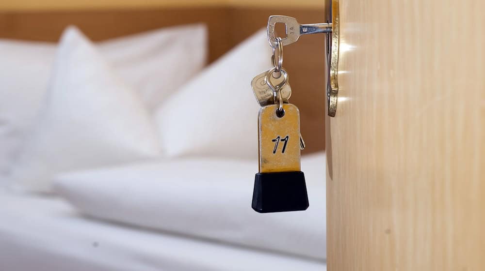 Ein Zimmerschlüssel hängt am 28.11.2014 in einem Gästehaus vor einem Bett im Türschloss. / Foto: Swen Pförtner/dpa