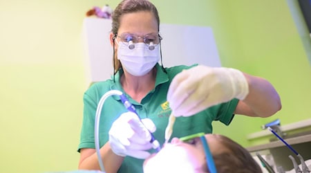 Eine Zahnärztin untersucht ein dreijähriges Kind in einer Kinderzahnarztpraxis. / Foto: Julian Stratenschulte/dpa/Illustrationen