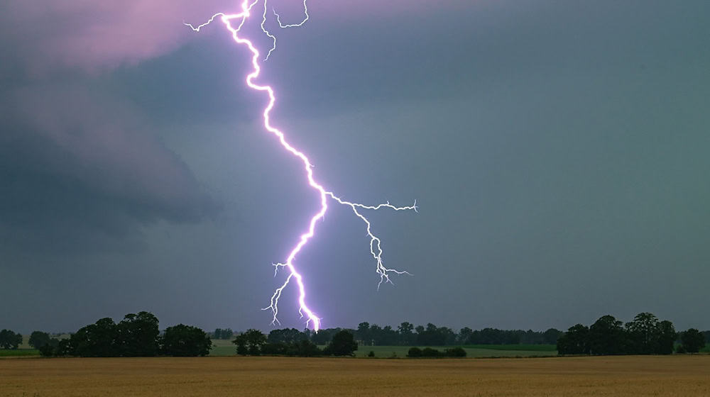 Ein Blitz leuchtet über einer Landschaft auf. / Foto: Patrick Pleul/dpa